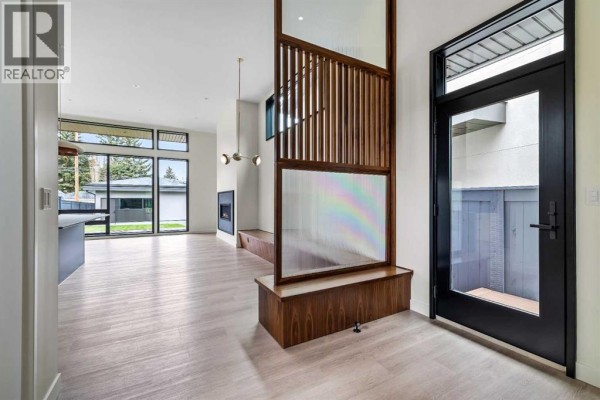 Interior view of a hallway showing a black glass door with a wood floor porch outside and a large walk-in closet. - 3d Willow Crescent Sw, Calgary