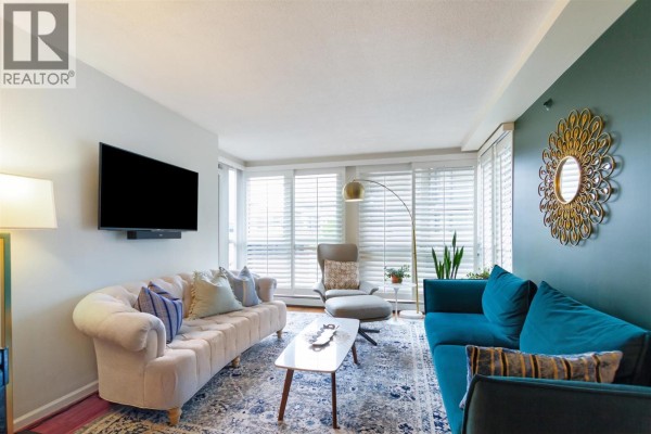 Living room with plush sofas, a marble-top coffee table, and white plantation shutters. - 3f 199 Drake Street, Vancouver