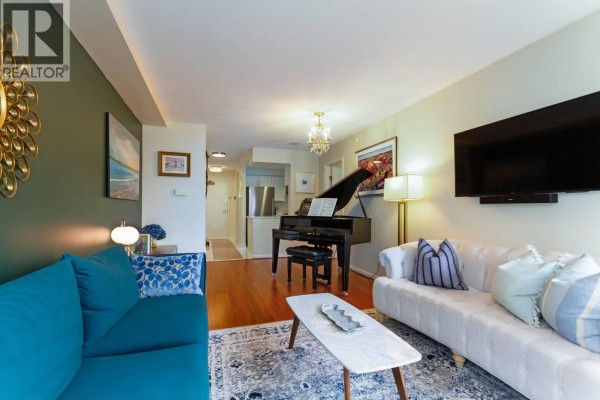 View of the living room, hallway, and kitchen area with a grand piano and seating. - 3f 199 Drake Street, Vancouver