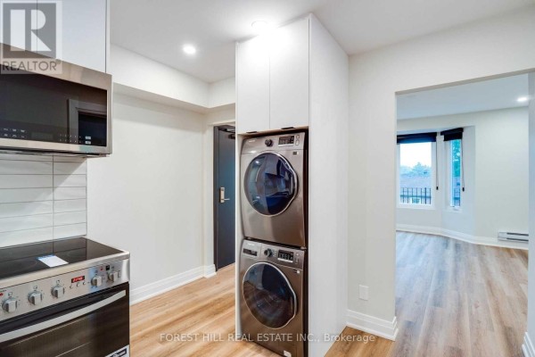 View of the kitchen with stainless steel appliances and white cabinetry. - 4 - 1 Greensides Avenue, Toronto