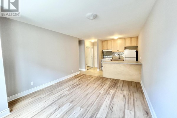 Open concept living area and kitchen with light wood floors. - 4 - 100 Twenty Fifth Street, Toronto