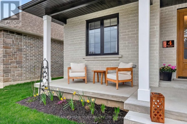 Covered front porch with two chairs, a side table, and decorative planters. - 4 - 1000 D'arcy Street, Cobourg