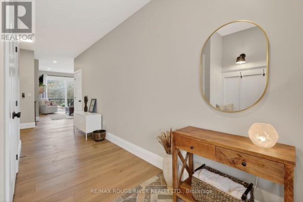 View down a hallway from the entryway, showing a console table and a doorway to a living area. - 4 - 1000 D'arcy Street, Cobourg