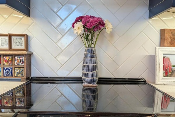 Close-up of a bouquet of pink and white mums in a blue and white vase on a stovetop. - 304 - 101 Pinhey Street, Ottawa