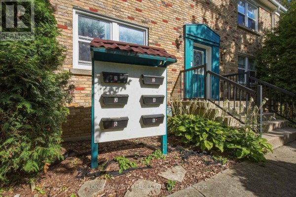 Mailboxes numbered 1 through 6 in front of a brick building with greenery. - 4 - 137 Windsor Crescent, London South
