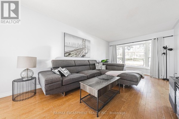 Living room with entertainment unit, sectional sofa, and view of the outdoors - 4 - 2220 Upper Middle Road, Burlington