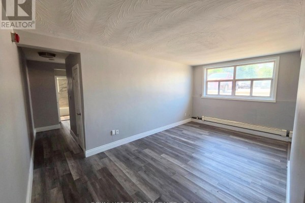 Living room with grey walls, wood-look flooring, and a view of the street outside. - 4 - 300 Montrave Avenue, Oshawa