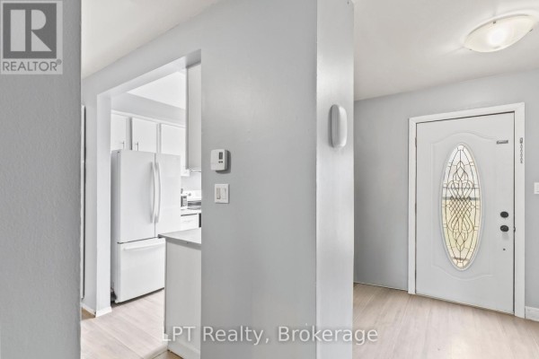Hallway entrance with view into a white kitchen with refrigerator and pantry. - 4 - 4 Tiffany Place, Quinte West