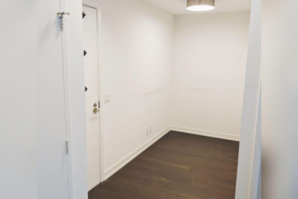 Empty room with dark hardwood floors and white walls, possibly a den. - 4 - 455 Front Street E, Toronto