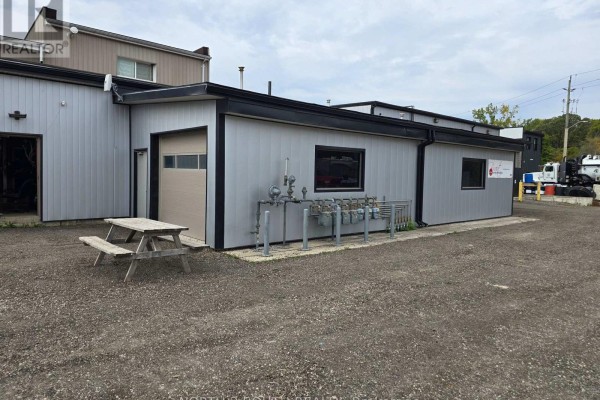 Side view of commercial building with light gray metal siding and gas meters. - 4 - 543 Greenwich Street, Brantford