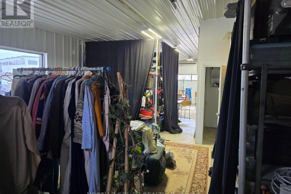 Interior space with clothes racks, black curtains, shelving, and a rug on the floor. - 4 - 543 Greenwich Street, Brantford