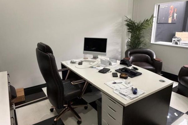 Office space with a desk, computer, office chair, and chairs near a window with a plant. - #4 - 5657 Hwy 7, Vaughan