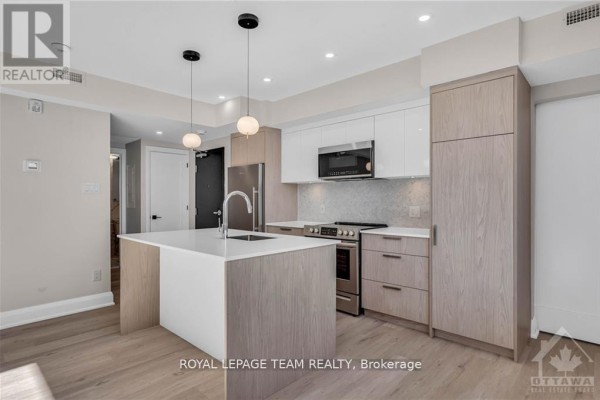 Kitchen with island, light wood and white cabinets, and stainless steel appliances. - 4 - 58 Florence Street, Ottawa