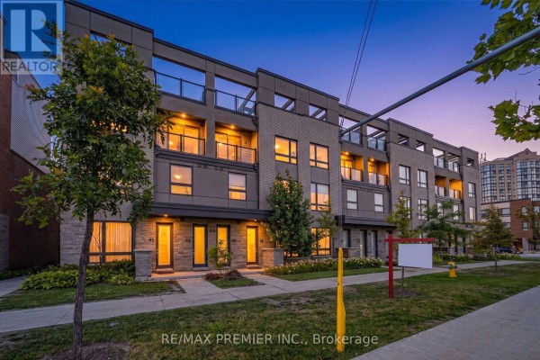 Open-concept living area with a sectional sofa, kitchen, and staircase. - 4 - 624 Rexdale Boulevard, Toronto