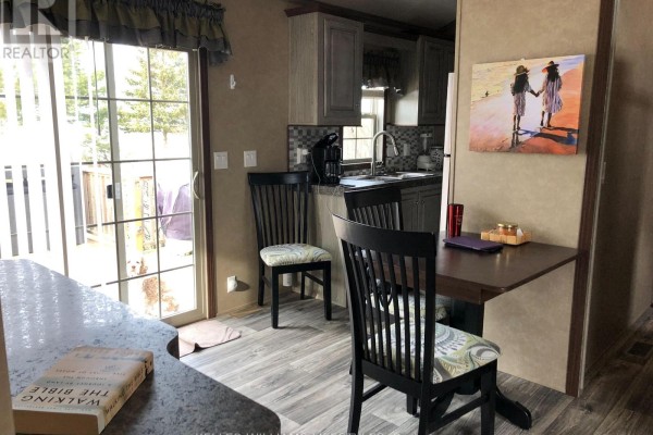 Dining space with view of kitchen, featuring a small table and outdoor access - 4 - 77719 Bluewater Highway, Central Huron
