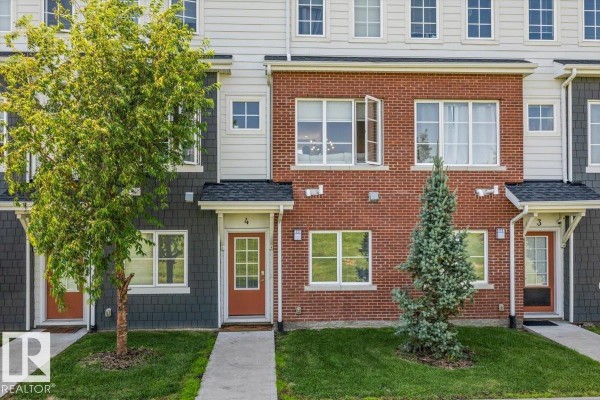 Exterior front view of townhouse #4 with red brick and dark siding. - #4 1636 Kerr Rd Nw, Edmonton