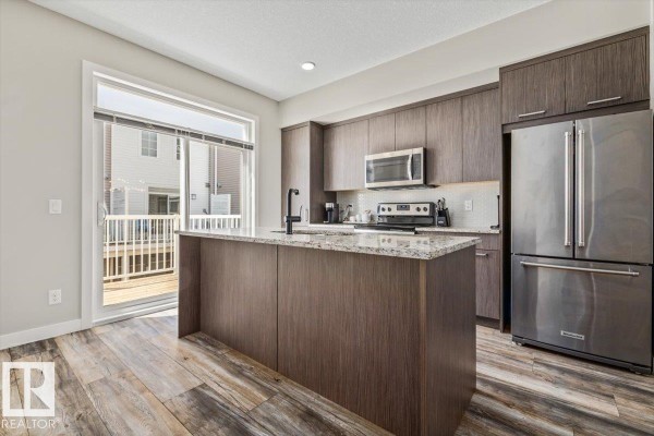 Entryway with a glass-paneled door and a window overlooking a field. - #4 1636 Kerr Rd Nw, Edmonton