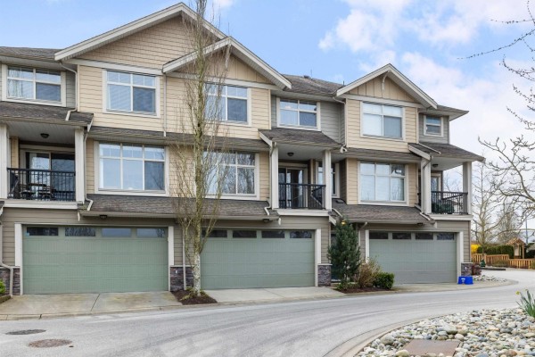 A balcony with black metal railings overlooking a street with townhouses and a playground. - 4 22225 50 Avenue, Langley