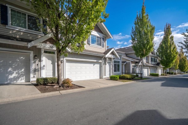 A row of townhouses with garages and trees along the street. - 4 30748 Cardinal Avenue, Abbotsford