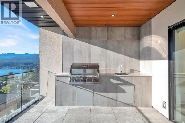 Open concept living space with white built-in cabinets, fireplace, dining area, and access to patio. - 4 7275 Ridge Drive, Burnaby