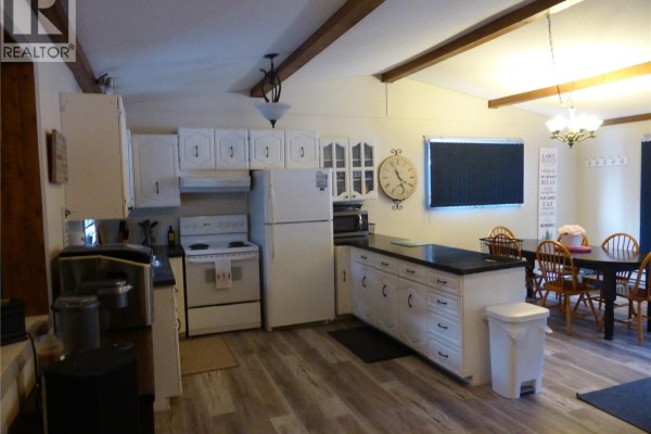 View from kitchen showing appliances and living area with TV - 4 Amalia Place, Kivimaa Moonlight Bay