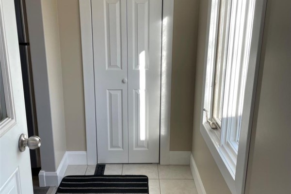 Interior hallway with a closet, beige walls, and a window with blinds. - 4 Bay Street, Little Burnt Bay