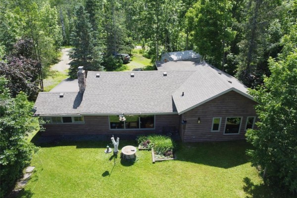 Aerial view of a rustic wooden house surrounded by trees, with a large grassy backyard. - 4 Block 4 Road, Otterfalls