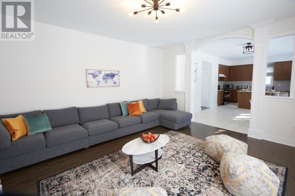 Grey sectional sofa, oval coffee table, and world map art in living room - 4 Boville Court Oro Medonte