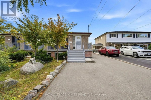 Close-up of the bungalow's brick exterior with a paved driveway and landscaping. - 4 Buttercup Court, Toronto