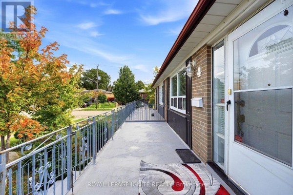 Exterior view of the bungalow's covered porch with metal railings and windows. - 4 Buttercup Court, Toronto