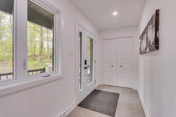 Interior entryway with white walls, tile flooring, a glass door, and a closet. - 4 Ch. Des Contes, Notre Dame De Pontmain
