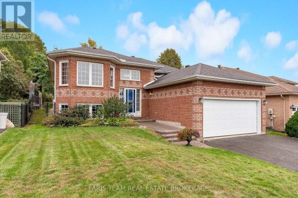 Front view of a red brick house with a lawn and a paved driveway leading to a double garage. - 4 Charles Street, Penetanguishene
