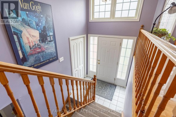 Interior foyer with wood railings on a staircase, a large Van Gogh print on a purple wall. - 4 Charles Street, Penetanguishene