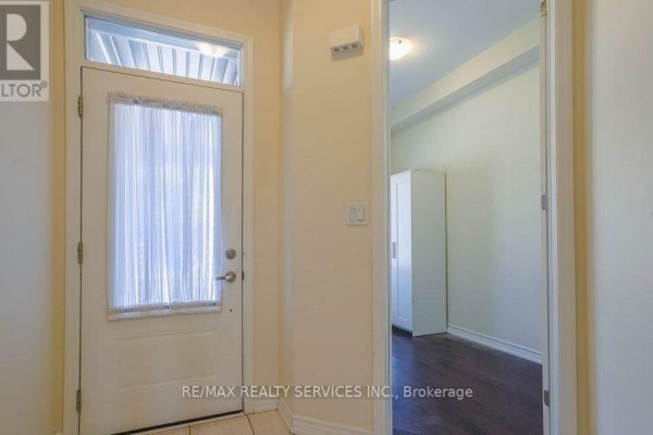Interior view of the front door with a sheer curtain and a hallway leading to a room with a white closet. - 4 Divers Road, Brampton