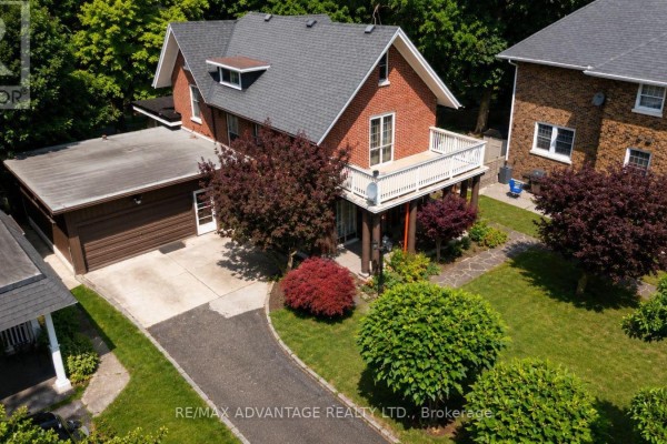 Side view of the brick house showing a stone walkway, garden beds, and a wooden fence. - 4 Farley Place, St  Thomas