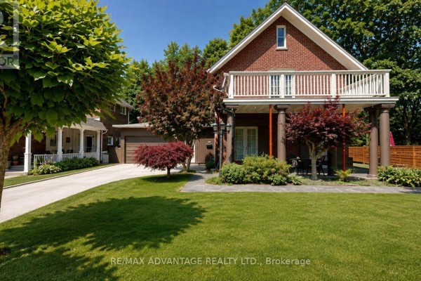 View of the house from the driveway with manicured trees and a large front lawn. - 4 Farley Place, St  Thomas