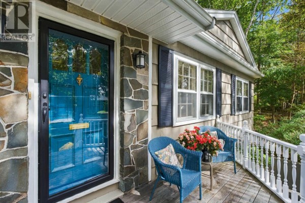 Detailed view of the porch with blue chairs, a small table, and the blue front door with stone siding. - 4 Fleming Drive, Halifax