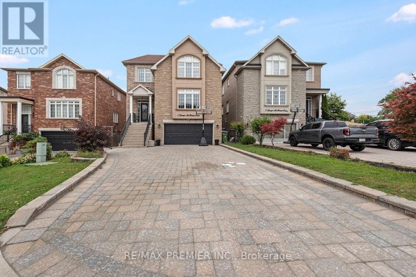 View of the front of a house from the driveway, with a dark grey truck parked on the right. - 4 George Mckenzie Court, Toronto