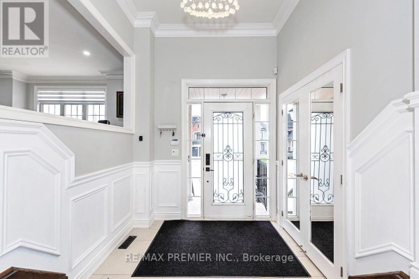 Interior entryway with light grey walls, white wainscoting, and double glass doors reflecting the exterior. - 4 George Mckenzie Court, Toronto
