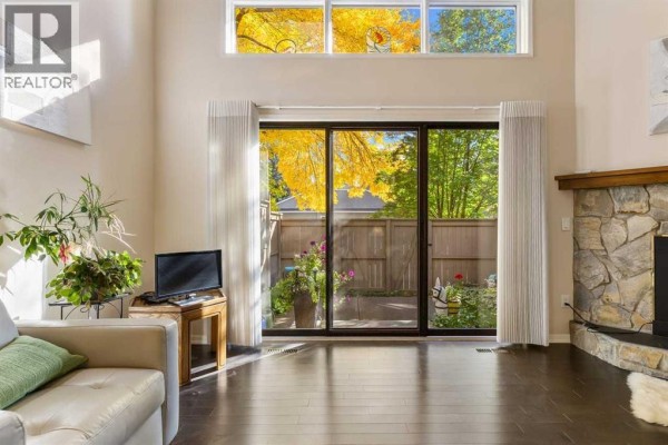Sliding glass doors opening to a private courtyard with trees and flowers. - 4 Glamis Gardens Sw, Calgary