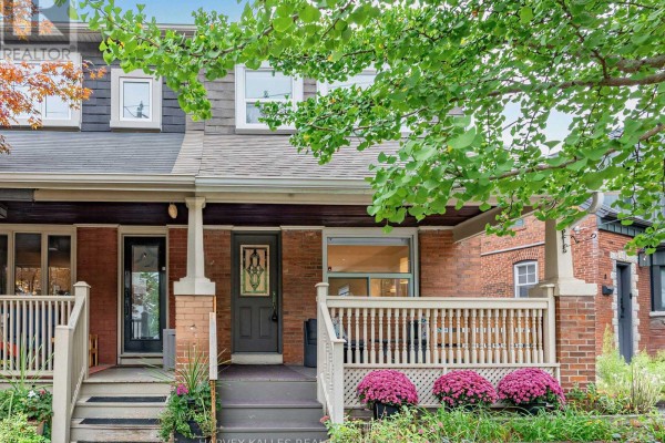 Close-up of the front of two brick houses with wooden porches and railings. - 4 Kenrae Road, Toronto