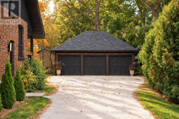Three-car garage with dark wooden doors and a gabled black shingle roof. - 4 King Street, Clearview