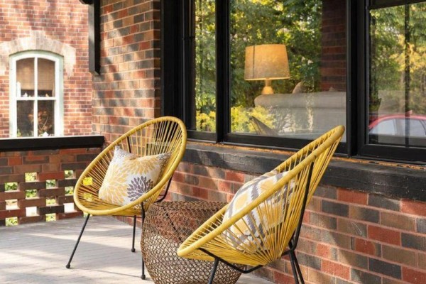 Two yellow wicker chairs and a small table on a brick front porch. - 4 King Street, Clearview