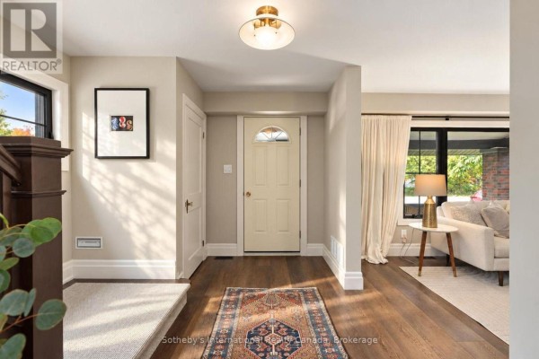 Foyer with beige walls, wood floors, a cream door, and a staircase. - 4 King Street, Clearview
