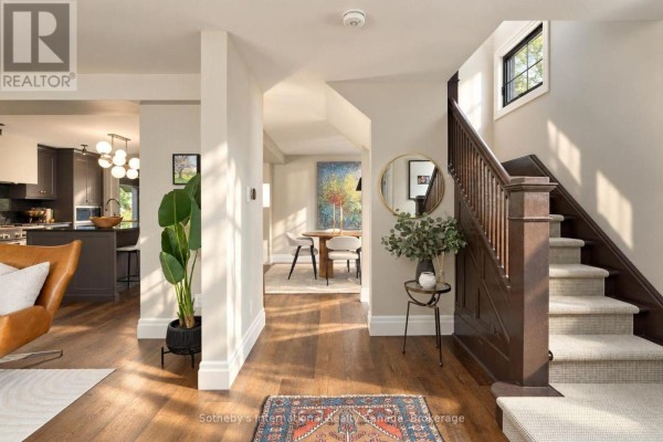 Hallway with wood floors, a staircase, a dining area, and a kitchen view. - 4 King Street, Clearview