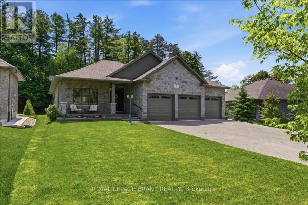 Front exterior of a stone house with a lawn and trees, featuring a three-car garage. - 4 Lynndale Road, Norfolk