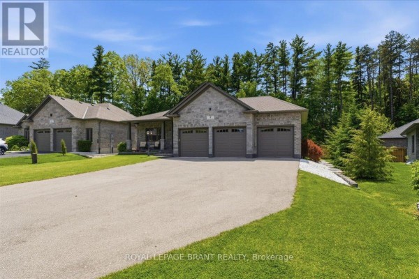 Side view of a stone house with a large driveway and grass, surrounded by trees. - 4 Lynndale Road, Norfolk