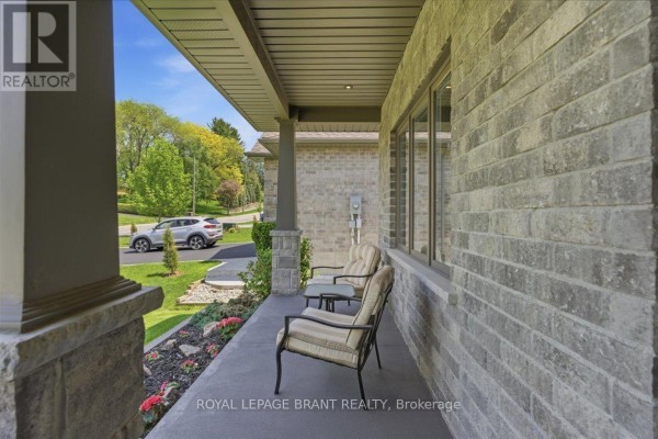 Covered porch with two chairs and a small table on a stone exterior, overlooking a street. - 4 Lynndale Road, Norfolk