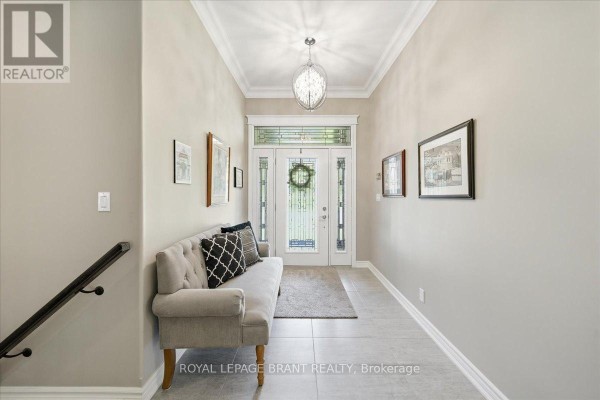 Foyer with light grey walls, tile floor, a grey sofa, and double glass doors. - 4 Lynndale Road, Norfolk