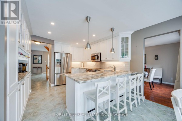 Kitchen and dining area showing white cabinets, granite countertops, and tiled floor. - 4 Milgate Place, Aurora
